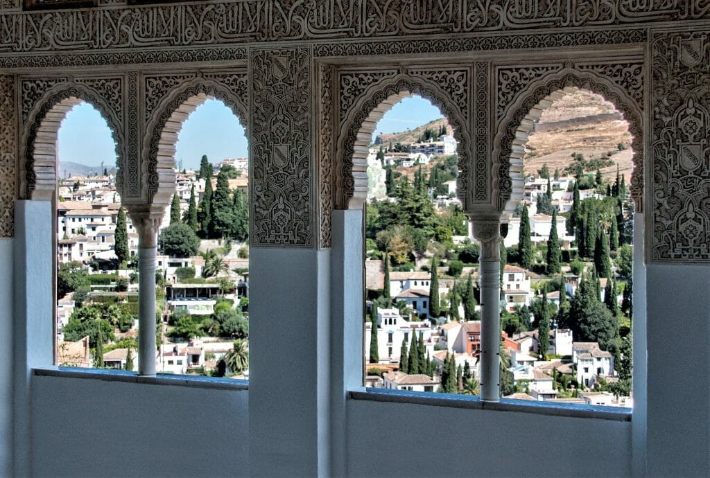 Albaicín hillside seen through the carved windows of the Alhambra, Granada, Spain