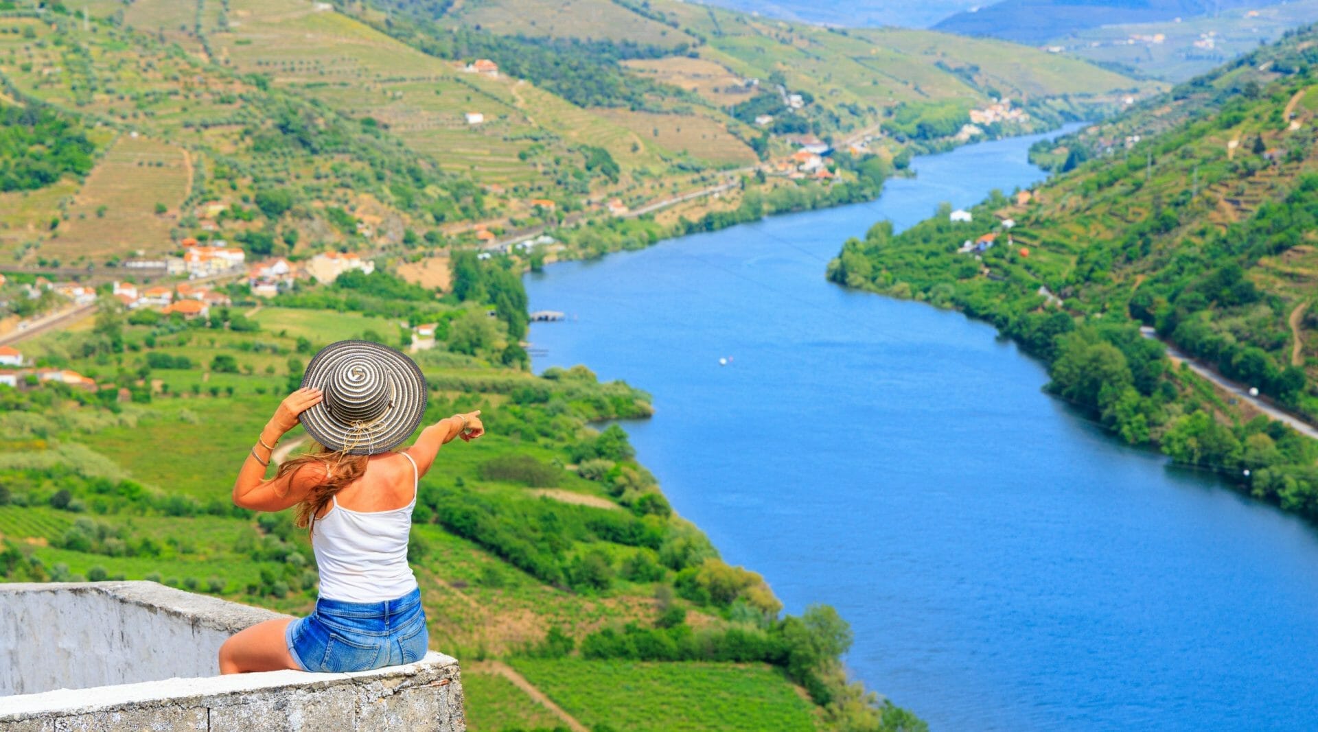 Woman tourist in the viewpoint admiring panoramic view of Douro valley in Portugal