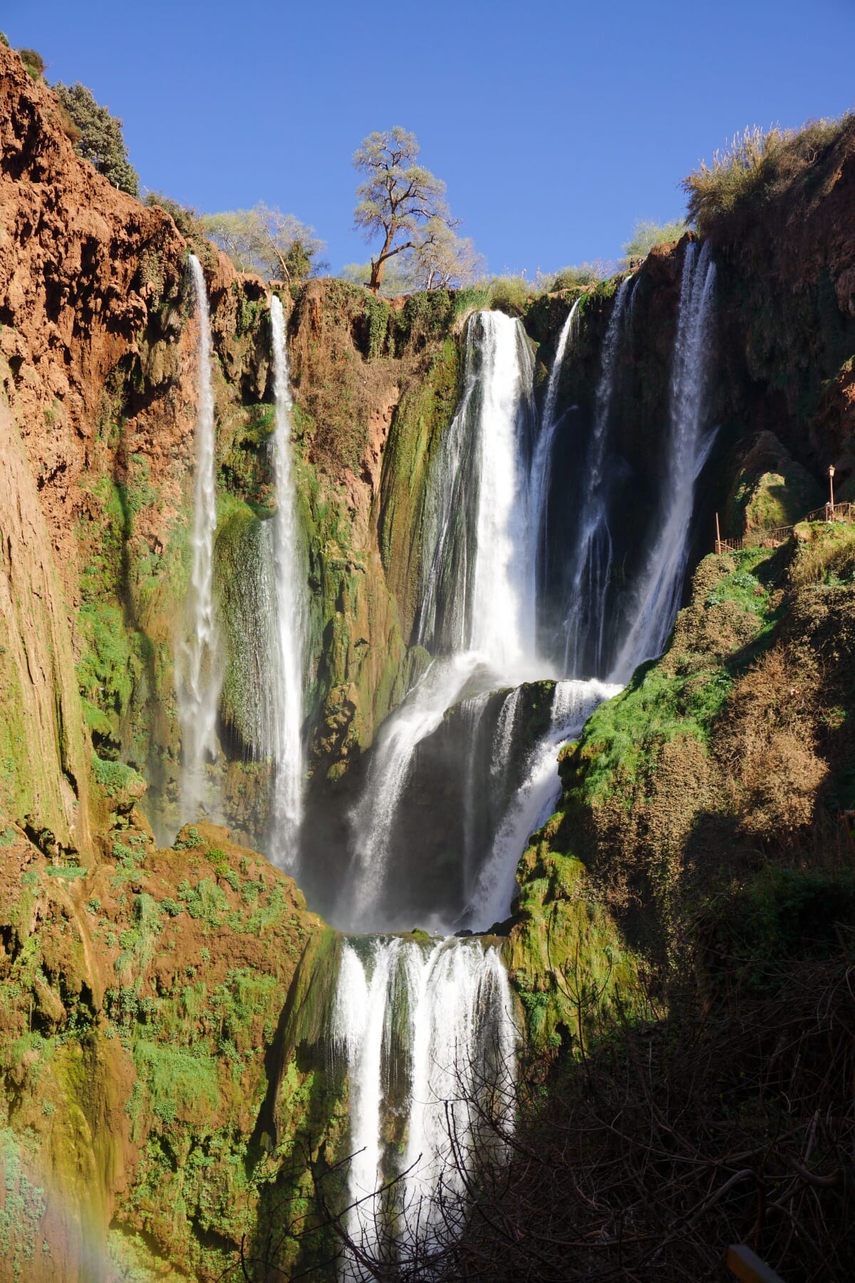Ouzoud waterfalls cascading down red cliffs in Morocco