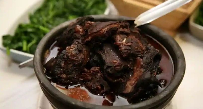 Chanfana, goat slow-cooked in red wine, served in a black clay pot, Coimbra, Portugal