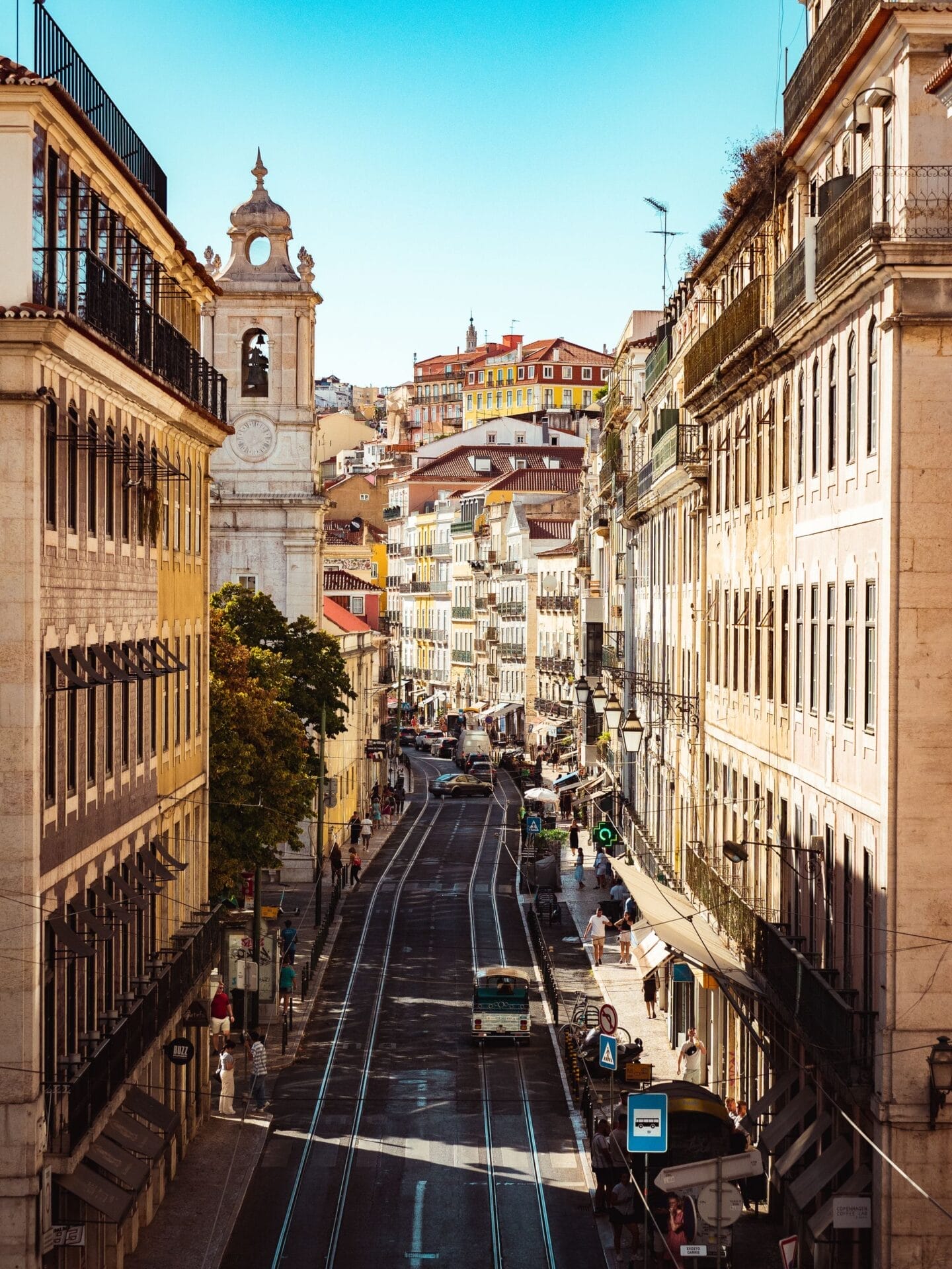 Historic Lisbon street lined with traditional buildings and red-tiled rooftops, Portugal.
