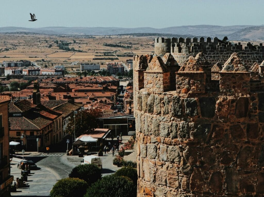 Crenellated tower on the Ávila wall walk above the rooftops and the Castilian plain, Ávila, Spain