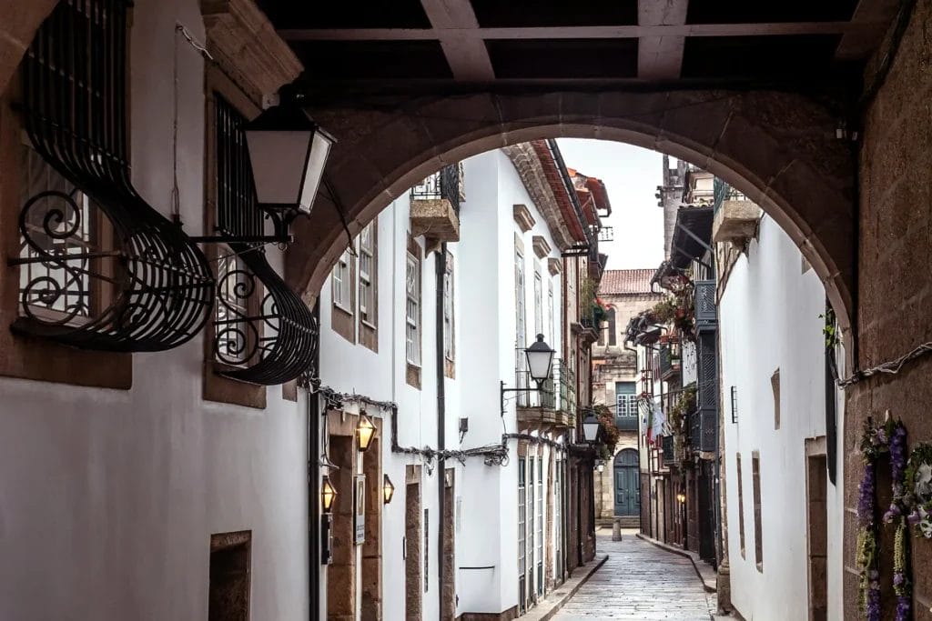 Narrow cobbled street seen through a stone arch in the medieval centre of Guimarães, Portugal