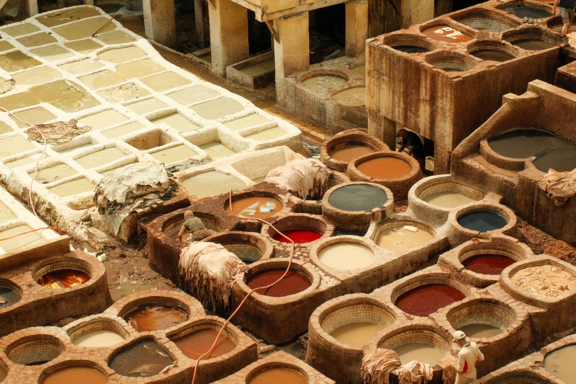 Stone vats of colored dye and white lime pits at a traditional leather tannery in the medina, Fez, Morocco