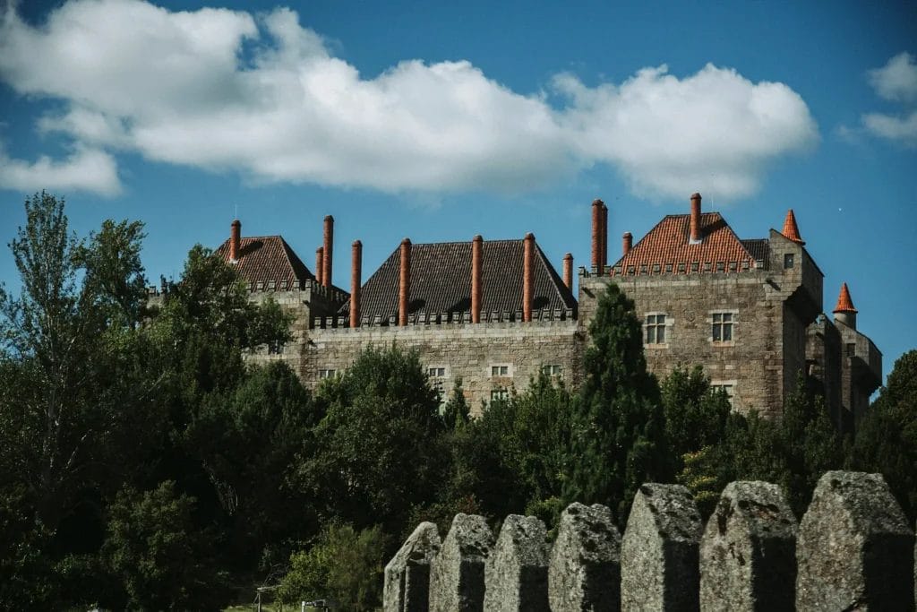 The Paço dos Duques de Bragança with its brick chimneys rising above the trees, Guimarães, Portugal